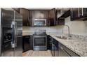 Stainless steel appliances and dark wood cabinets in kitchen at 2472 Temple Grove Ln, Kissimmee, FL 34741