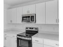 Modern kitchen with stainless steel appliances, white cabinetry, sleek countertops, and an electric range at 349 River Front Way, Edgewater, FL 32141