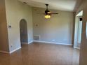 Bright living room featuring neutral walls, high ceiling with fan, archway and tiled floors at 806 Grantham Dr, Kissimmee, FL 34758