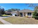 Single-story house with a white garage door and a manicured lawn at 4490 Treasure Cay Rd, Tavares, FL 32778