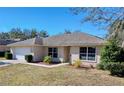 One-story house featuring a white garage door and well-maintained yard at 4490 Treasure Cay Rd, Tavares, FL 32778