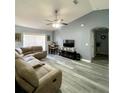 Spacious living room featuring neutral decor, wood-look flooring, and a large sectional sofa at 4490 Treasure Cay Rd, Tavares, FL 32778