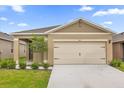 Inviting one-story home with a two-car garage, charming landscaping, and a covered front entry at 957 King Parc Rd, Orange City, FL 32763