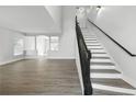 Bright entryway featuring wood-look flooring, staircase with dark railing, and neutral paint color at 724 Tahiti Dr, Kissimmee, FL 34758