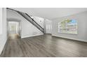 Spacious living room featuring light gray wood-look floors, staircase, and arched entry at 724 Tahiti Dr, Kissimmee, FL 34758