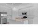 Modern kitchen with stainless steel appliances, quartz countertops, kitchen island, and white cabinets at 4945 Worchester Dr, Kissimmee, FL 34746