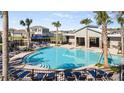 Community pool with lounge chairs, palm trees, and covered grilling and picnic area perfect for hot summer days at 4945 Worchester Dr, Kissimmee, FL 34746