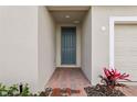 Inviting entryway featuring a covered porch with brick pavers and a stylish front door at 1390 Current Pl, Haines City, FL 33844