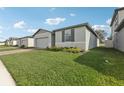 Well-kept lawn surrounds a one-story home with brick accents and a gray exterior at 1542 Mermaid Way, Haines City, FL 33844