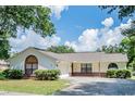 House with a white exterior, brick accents, and a two-car garage at 106 Summerhill Ct, Minneola, FL 34715