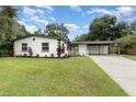 Beautifully landscaped home featuring a carport and lush green lawn at 2524 Dellwood Dr, Orlando, FL 32806