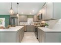 Modern kitchen featuring grey cabinetry, stainless steel appliances, and a large island at 2524 Dellwood Dr, Orlando, FL 32806