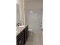 Well-lit bathroom features a double vanity with granite countertops and a shower-tub combo at 1926 Church Lake St, Groveland, FL 34736