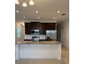 Modern kitchen featuring granite countertops, dark wood cabinets, and stainless steel appliances at 1926 Church Lake St, Groveland, FL 34736