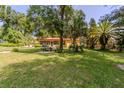 Lush backyard featuring a patio with seating and a grill, perfect for outdoor entertaining and relaxation surrounded by trees at 1546 Stormway Ct, Apopka, FL 32712