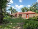 A neatly landscaped front yard with a brick home, complemented by mature trees at 1546 Stormway Ct, Apopka, FL 32712