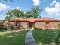 Charming single-story brick home with a well-manicured lawn and mature trees at 1546 Stormway Ct, Apopka, FL 32712