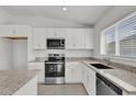 Bright kitchen with stainless steel appliances, granite countertops, white cabinets, and modern fixtures at 3409 Narrows Dr, Lakeland, FL 33810