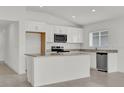 Modern kitchen showcasing white cabinetry, stainless steel microwave, granite counters, and tile flooring at 3409 Narrows Dr, Lakeland, FL 33810