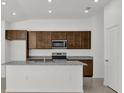 Close up on kitchen featuring dark wood cabinets, granite countertops, and stainless steel appliances at 8645 Caribbean Pine Way, Lakeland, FL 33809