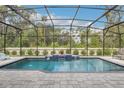 Screened-in pool with waterfall feature, brick patio and view of the backyard at 1087 Conestoga Way, Sanford, FL 32771