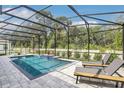 Screened-in pool with brick surround and lounge chairs offers a relaxing backyard retreat at 1087 Conestoga Way, Sanford, FL 32771