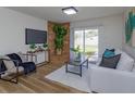 A bright living room with modern decor, featuring a brick accent wall, a cozy chair, and access to the backyard at 220 Lake Gene Dr, Longwood, FL 32779