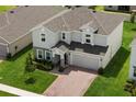 Aerial view of a beautiful, two-story home with a brick-paved driveway and well-maintained landscaping at 463 Shadow Gorge Way, Eustis, FL 32736