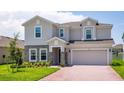 Charming two-story home featuring a well-manicured lawn and a brick-paved driveway leading to a two-car garage at 463 Shadow Gorge Way, Eustis, FL 32736