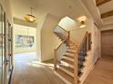 Elegant foyer featuring a staircase with wood treads, black iron railings, and a view into the dining room at 1730 Winchester Dr, Winter Park, FL 32789