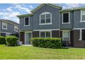 Two-story home with a gray exterior, sliding glass door, well-manicured lawn, and lush greenery at 6604 S Goldenrod Rd # 100B, Orlando, FL 32822