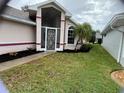 House exterior featuring a screened porch and landscaped yard at 5610 King James Ave, Leesburg, FL 34748