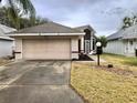 House exterior featuring a two-car garage and well-maintained lawn at 5610 King James Ave, Leesburg, FL 34748