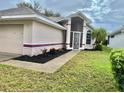 Charming home featuring a well-maintained lawn, manicured landscaping, and covered front entry at 5610 King James Ave, Leesburg, FL 34748