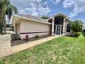 Inviting home featuring a walkway to the front door, manicured lawn, and fresh landscaping at 5610 King James Ave, Leesburg, FL 34748