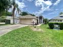 Charming single Gathering home with well-maintained lawn, front yard, and two car garage at 5610 King James Ave, Leesburg, FL 34748