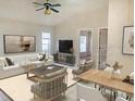 Spacious living room with tile floors and open floorplan has comfortable seating and neutral colors, allowing for natural light at 5610 King James Ave, Leesburg, FL 34748