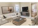 Bright living room featuring a comfortable sofa, modern artwork, and natural light from the window at 5610 King James Ave, Leesburg, FL 34748