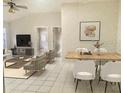 Open-concept living room featuring tile floors, neutral walls, and comfortable seating with dining area and bright, natural light at 5610 King James Ave, Leesburg, FL 34748