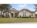 Single story home with beige and gray siding, tile roof, and well manicured lawn at 31722 Red Tail Blvd, Sorrento, FL 32776