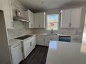 Bright kitchen with white cabinets, quartz countertops, and a stainless steel range hood at 1189 Basalt Ln, Sanford, FL 32771