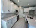 Spacious kitchen featuring stainless steel appliances, white cabinets, and quartz countertops at 1193 Basalt Ln, Sanford, FL 32771