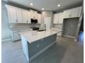 Bright kitchen featuring white cabinets, a center island, and modern stainless steel appliances at 1193 Basalt Ln, Sanford, FL 32771