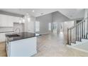 Bright, open-concept living area with stylish tile flooring, stairs, and access to the modern kitchen at 1211 Teal Creek Dr, St Cloud, FL 34771
