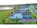Aerial view showcasing the house with a brick driveway, three-car garage, and view of a lake at 16744 Sanctuary Dr, Winter Garden, FL 34787