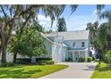 Two-story light blue home with a metal roof, well-maintained lawn, and lush landscaping at 12428 Summerport Ln, Windermere, FL 34786