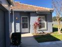 Inviting one-story home with a security door, colorful landscaping, and neutral color scheme at 4559 Oak Arbor Cir, Orlando, FL 32808