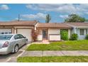 Single-story home with attached garage, manicured lawn, and lush landscaping for inviting curb appeal at 5875 Talavera St, Orlando, FL 32807