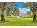 Charming single-story home with a well-manicured lawn framed by mature trees, offering a serene setting at 8368 Rambling River Dr, Sanford, FL 32771