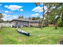 Large backyard featuring a screened-in porch and a canoe in a well-maintained lawn at 250 Shady Oaks Cir, Lake Mary, FL 32746